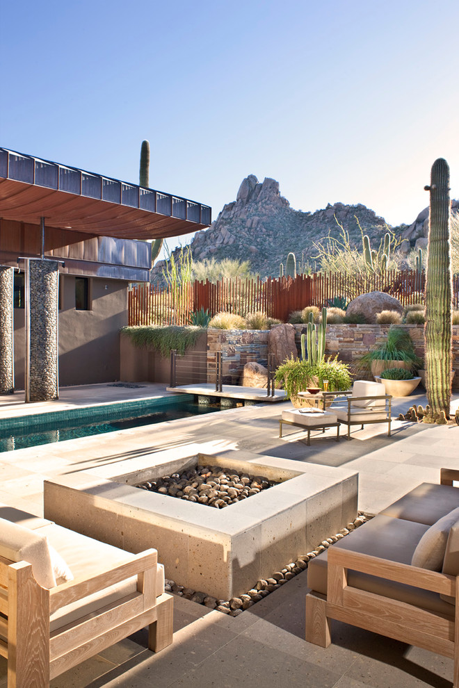 Design ideas for an expansive backyard patio in Phoenix with natural stone pavers, no cover and a fire feature.