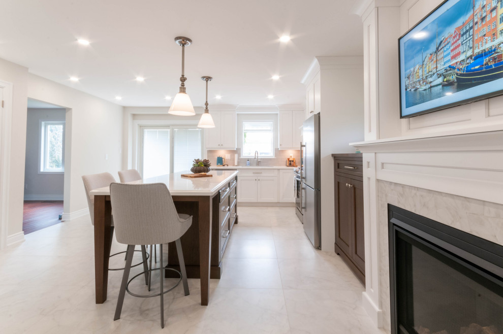 Large transitional l-shaped porcelain tile and white floor eat-in kitchen photo in Toronto with an undermount sink, recessed-panel cabinets, white cabinets, quartz countertops, gray backsplash, ceramic backsplash, stainless steel appliances, an island and white countertops