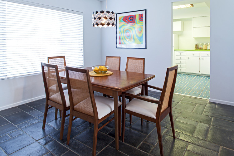 This is an example of a midcentury separate dining room in Phoenix with white walls, slate floors and no fireplace.