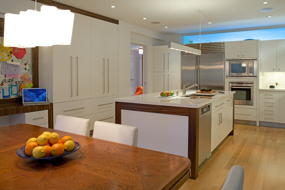 Contemporary eat-in kitchen in Toronto with stainless steel appliances, an undermount sink, flat-panel cabinets and white cabinets.