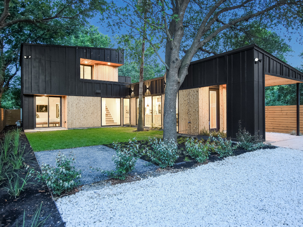 Inspiration for an industrial two-storey black house exterior in Austin with wood siding and a shed roof.