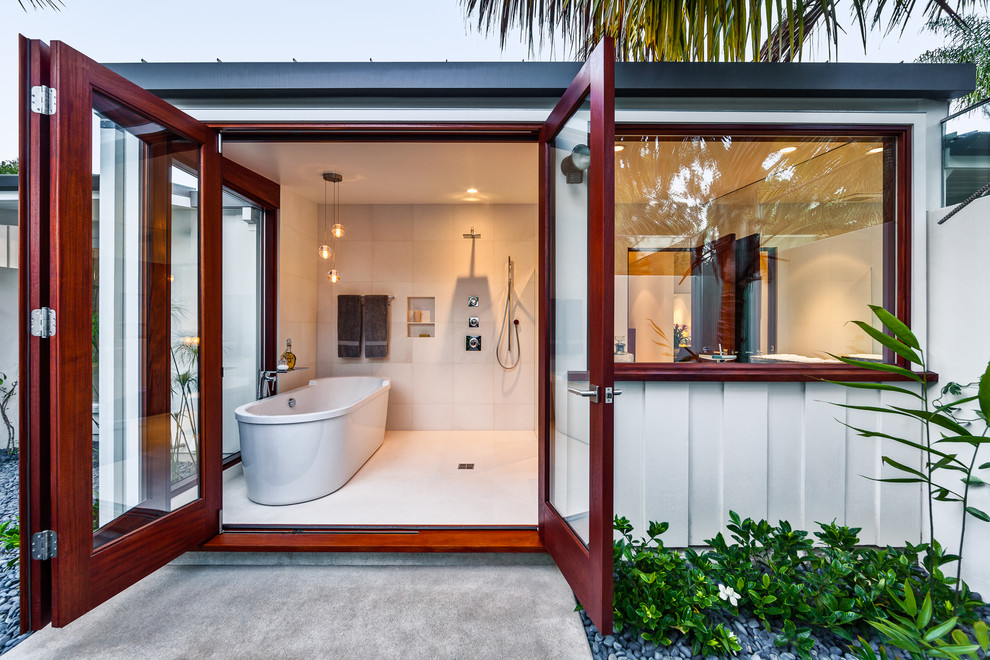 This is an example of a tropical bathroom in Santa Barbara with a freestanding tub and a curbless shower.