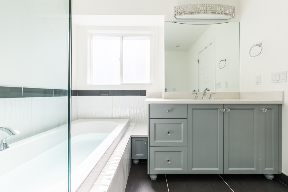 Inspiration for a mid-sized transitional master white tile and ceramic tile ceramic tile drop-in bathtub remodel in Calgary with recessed-panel cabinets, gray cabinets, white walls, an undermount sink and quartz countertops