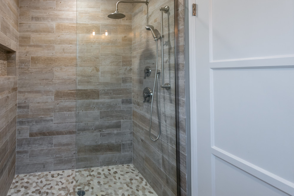 Mid-sized beach style 3/4 bathroom in Los Angeles with furniture-like cabinets, medium wood cabinets, an alcove shower, a two-piece toilet, brown tile, gray tile, porcelain tile, grey walls, an undermount sink and quartzite benchtops.