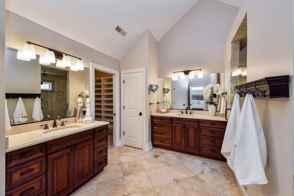 Large transitional master beige tile and porcelain tile porcelain tile, double-sink, vaulted ceiling and beige floor drop-in bathtub photo in Chicago with brown cabinets, beige walls, an undermount sink, recessed-panel cabinets, quartzite countertops, a hinged shower door, beige countertops and a built-in vanity