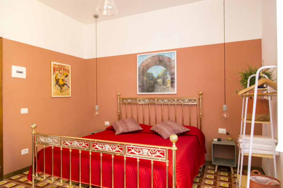 Modelo de dormitorio principal retro de tamaño medio con suelo de baldosas de terracota, marco de chimenea de yeso, suelo multicolor y panelado