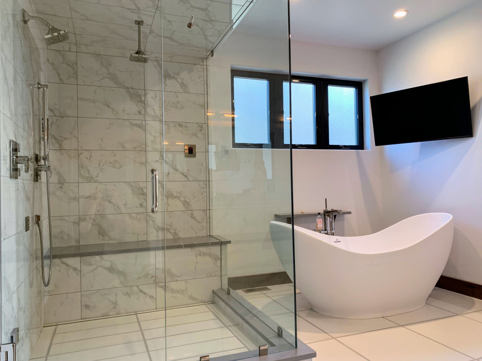 This is an example of a large modern master wet room bathroom in Denver with flat-panel cabinets, light wood cabinets, a freestanding tub, a wall-mount toilet, black and white tile, porcelain tile, white walls, porcelain floors, an undermount sink, engineered quartz benchtops, white floor, a hinged shower door, a shower seat, a built-in vanity, a double vanity and grey benchtops.