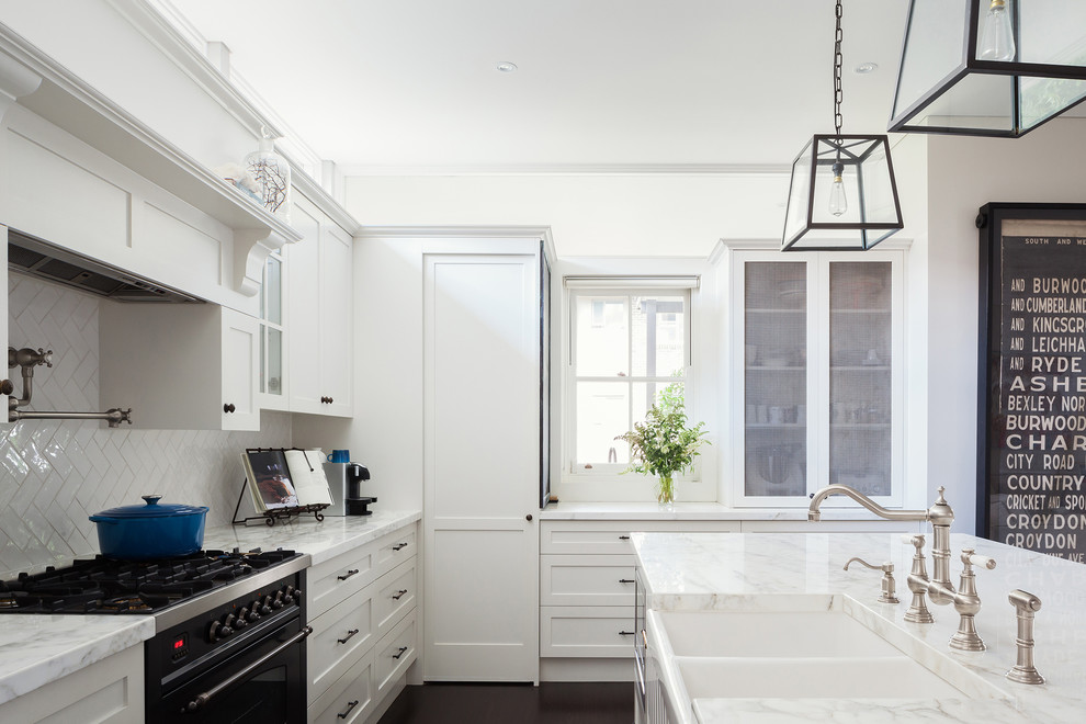 Inspiration for a large transitional u-shaped eat-in kitchen in Sydney with a double-bowl sink, raised-panel cabinets, white cabinets, marble benchtops, white splashback, ceramic splashback, stainless steel appliances, dark hardwood floors, with island and black floor.