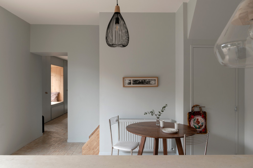 Esempio di una grande sala da pranzo aperta verso il soggiorno mediterranea con pareti grigie, pavimento in terracotta, pavimento beige e pareti in legno