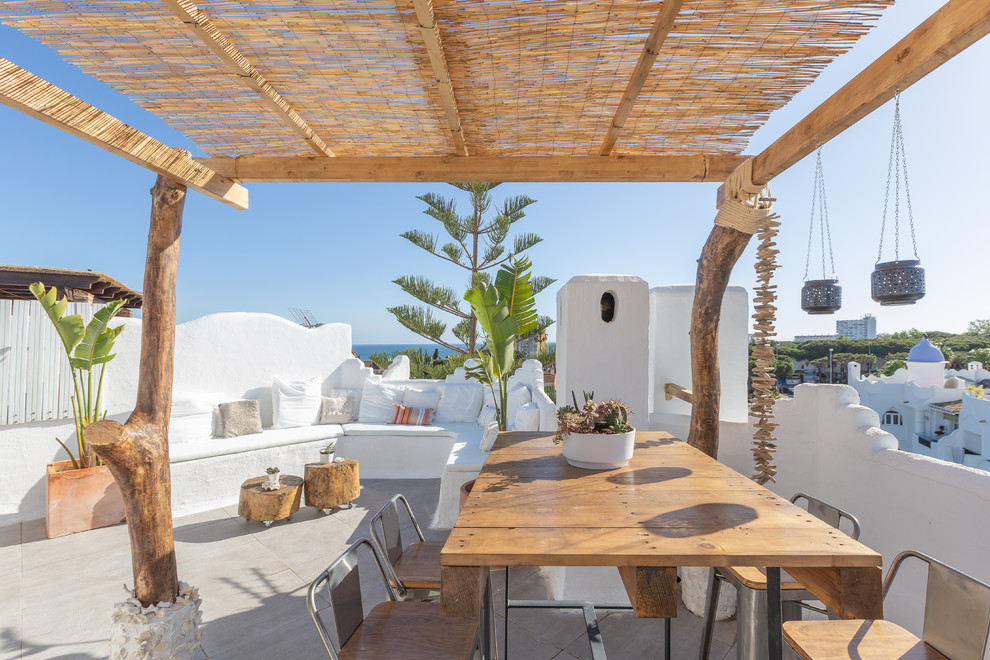 This is an example of a mid-sized mediterranean rooftop and rooftop deck in Malaga with a container garden and a pergola.