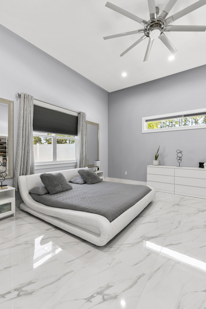 Photo of a beach style master bedroom in Jacksonville with green walls, marble floors, white floor and recessed.