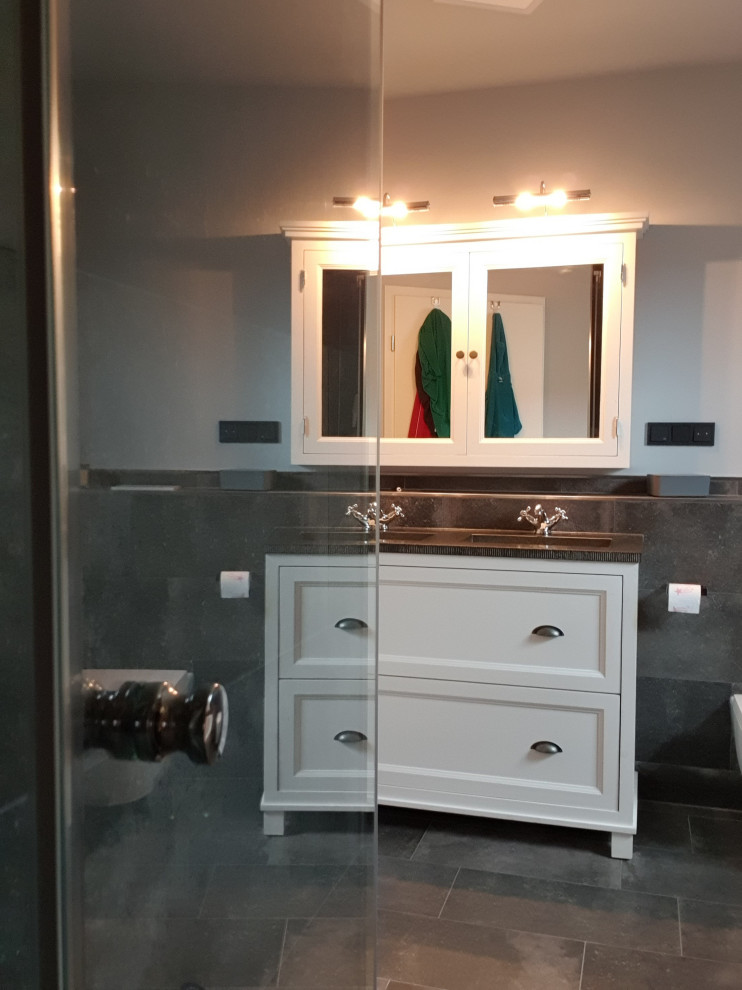 Пример оригинального дизайна: серо-белая ванная комната среднего размера в стиле лофт с фасадами с декоративным кантом, белыми фасадами, накладной ванной, душем в нише, раздельным унитазом, серой плиткой, керамической плиткой, белыми стенами, полом из керамической плитки, врезной раковиной, столешницей из гранита, серым полом, черной столешницей, сиденьем для душа, тумбой под две раковины и встроенной тумбой