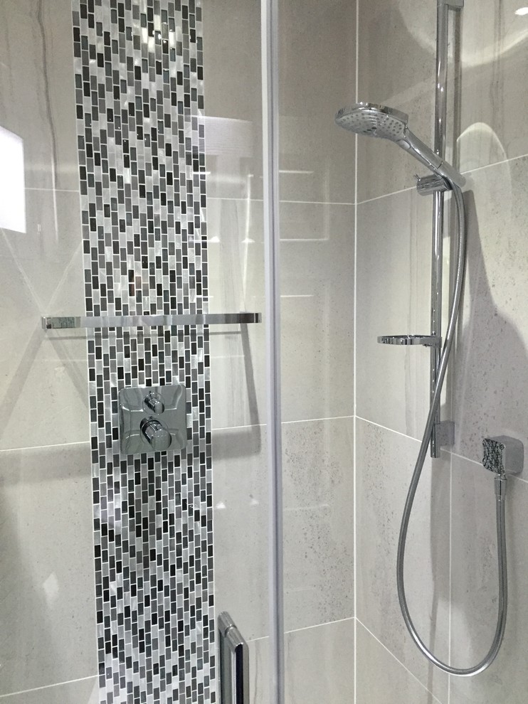 Design ideas for a modern bathroom in Essex with black cabinets, a corner shower and grey tiles.