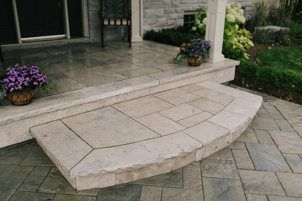 Photo of a mid-sized traditional front yard patio in Toronto with natural stone pavers and a roof extension.
