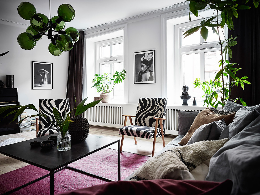 This is an example of a scandinavian living room in Gothenburg with white walls, light hardwood floors and beige floor.