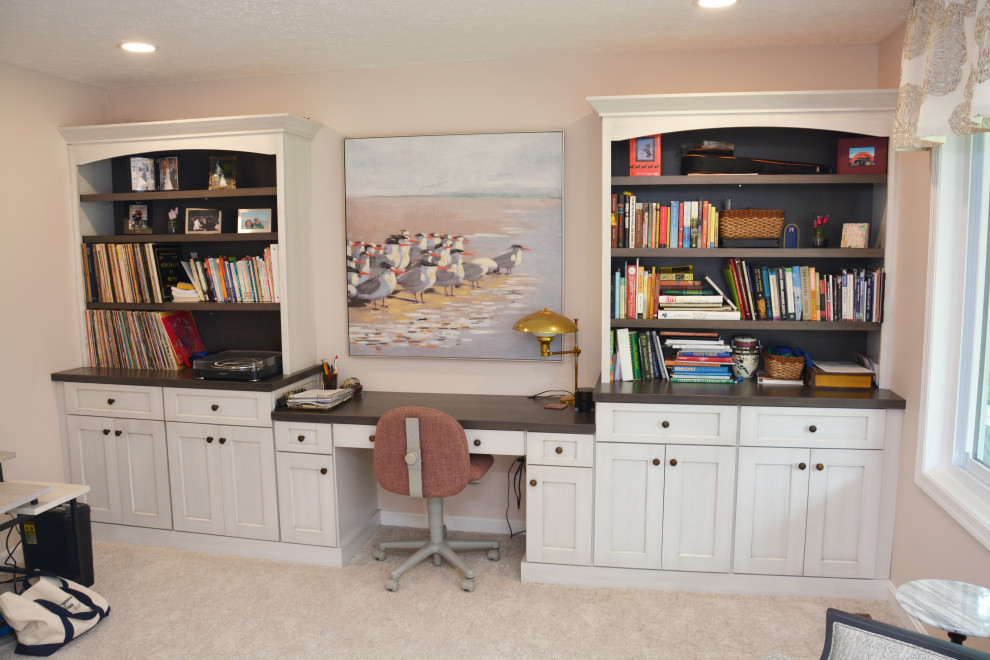 Large traditional home office in Baltimore with a library, white walls, carpet, no fireplace, a built-in desk and beige floor.