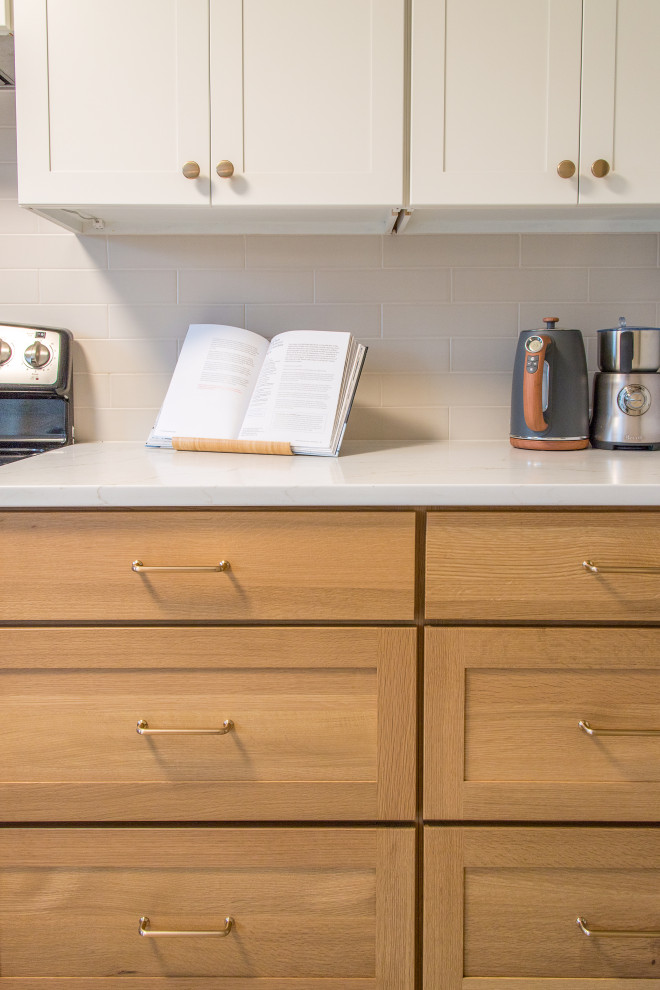 Eat-in kitchen - mid-sized transitional u-shaped light wood floor and brown floor eat-in kitchen idea with shaker cabinets, white cabinets, white backsplash, subway tile backsplash, no island and white countertops