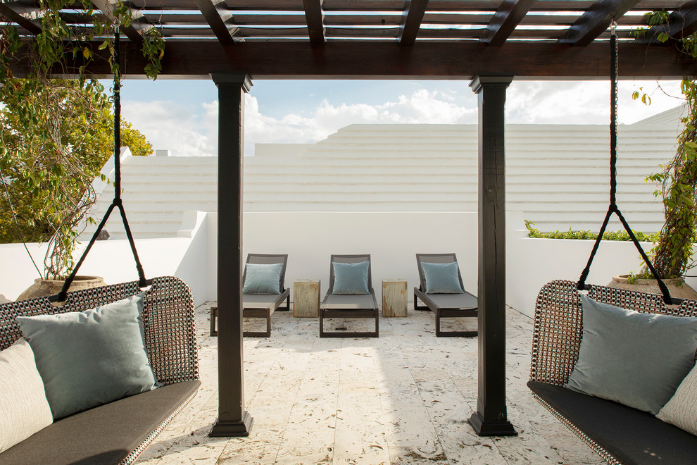 Photo of a large beach style balcony with a pergola.