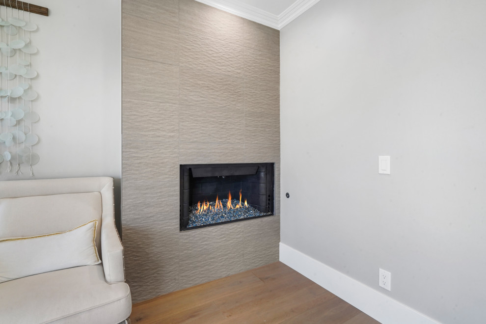 Photo of a large modern home office in Orange County with white walls, a corner fireplace and a tile fireplace surround.