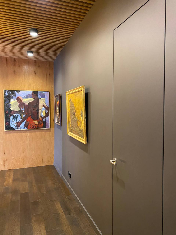 Скрытые двери в одном стиле со стеновыми панелями и реечное обрамление потолка