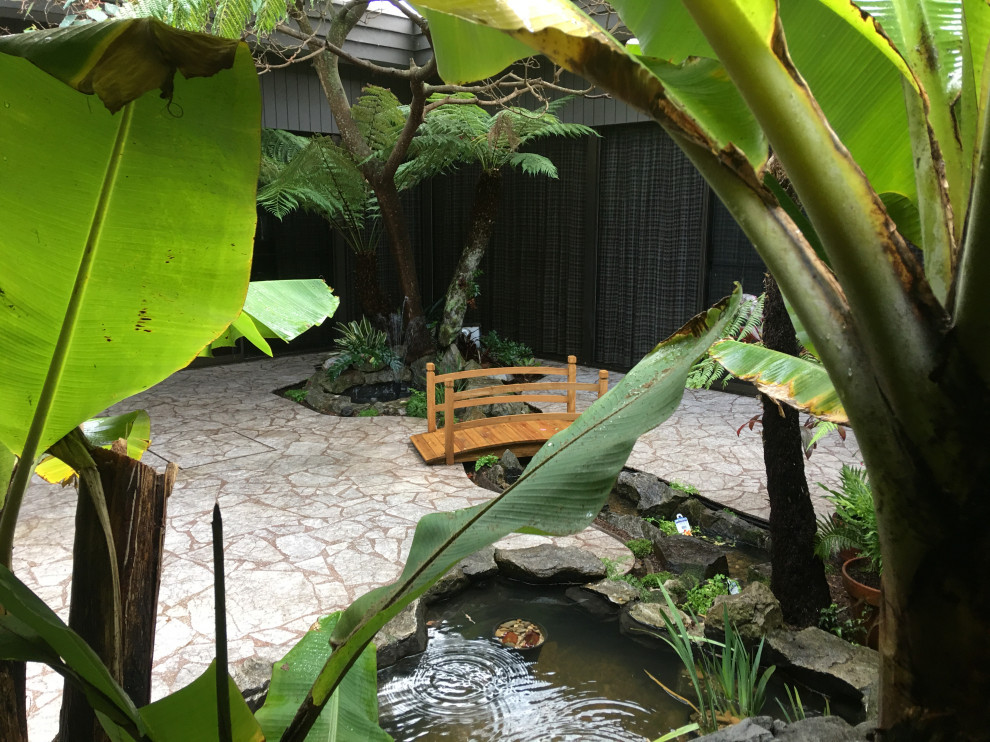 Diseño de jardín clásico renovado de tamaño medio en patio con estanque, exposición parcial al sol y adoquines de piedra natural
