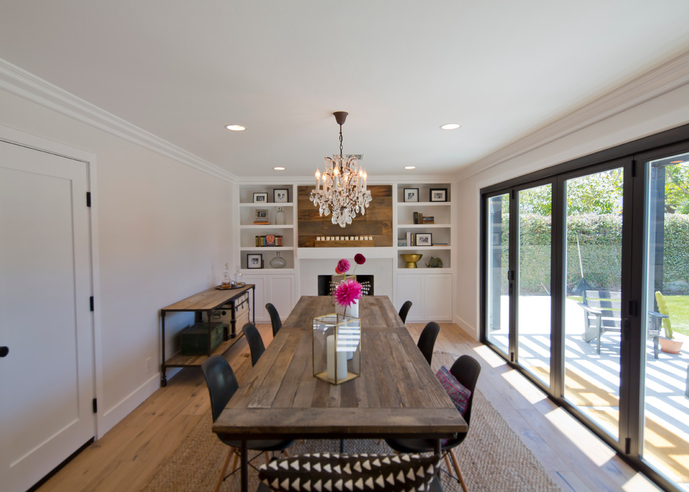 Mid-sized transitional separate dining room in Orange County with beige walls, light hardwood floors and a standard fireplace.