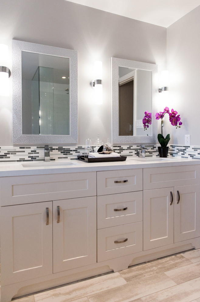 Photo of a mid-sized transitional master bathroom in Toronto with an undermount sink, shaker cabinets, white cabinets, engineered quartz benchtops, a curbless shower, a one-piece toilet, gray tile, porcelain tile, grey walls and porcelain floors.