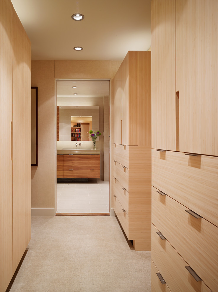 Inspiration for a large modern gender-neutral dressing room in San Francisco with flat-panel cabinets, light wood cabinets and carpet.