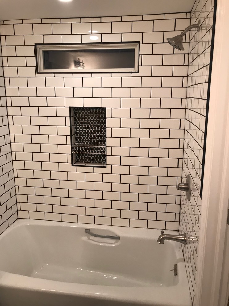 This is an example of a small modern master bathroom in New York with shaker cabinets, white cabinets, an alcove tub, a shower/bathtub combo, a two-piece toilet, black and white tile, subway tile, white walls, cement tiles, a drop-in sink, solid surface benchtops, black floor and a shower curtain.