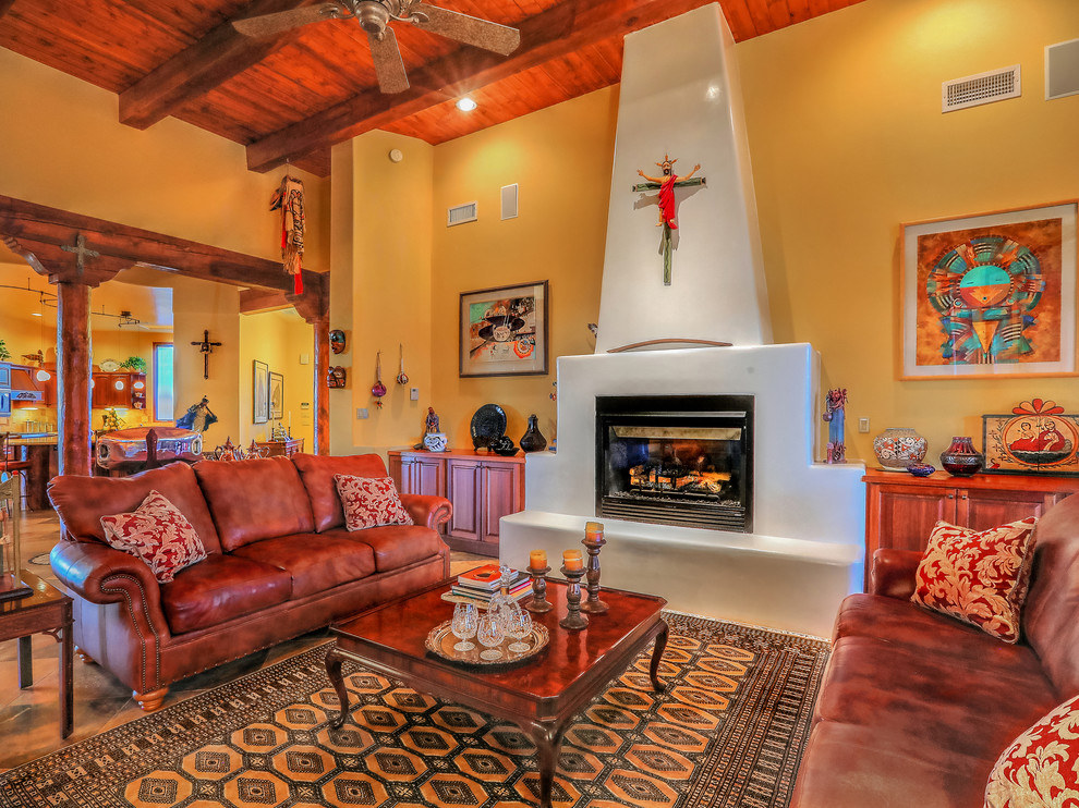 Mid-sized open concept living room in Albuquerque with multi-coloured walls, slate floors, a standard fireplace, a plaster fireplace surround, no tv and multi-coloured floor.