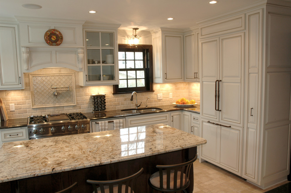 Large traditional l-shaped separate kitchen in Minneapolis with an undermount sink, recessed-panel cabinets, white cabinets, granite benchtops, beige splashback, ceramic splashback, white appliances, ceramic floors, with island and beige floor.
