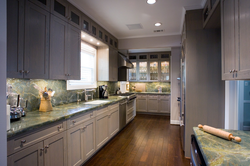 This is an example of a mid-sized contemporary galley separate kitchen in Houston with an undermount sink, recessed-panel cabinets, grey cabinets, marble benchtops, green splashback, stone slab splashback, stainless steel appliances, medium hardwood floors and no island.