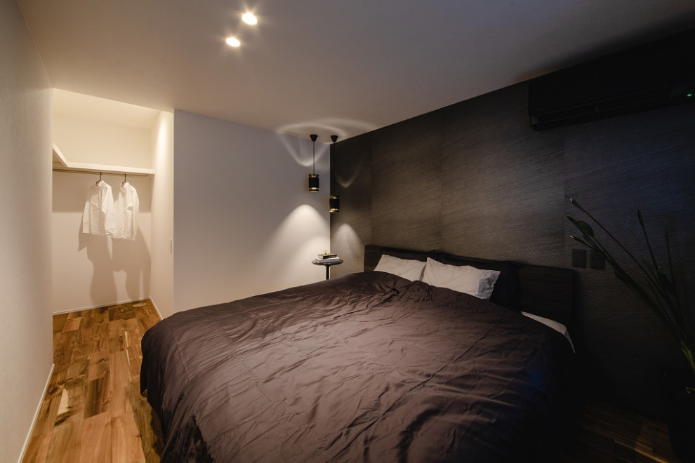 Diseño de dormitorio actual con paredes negras, suelo de madera en tonos medios, papel pintado y papel pintado