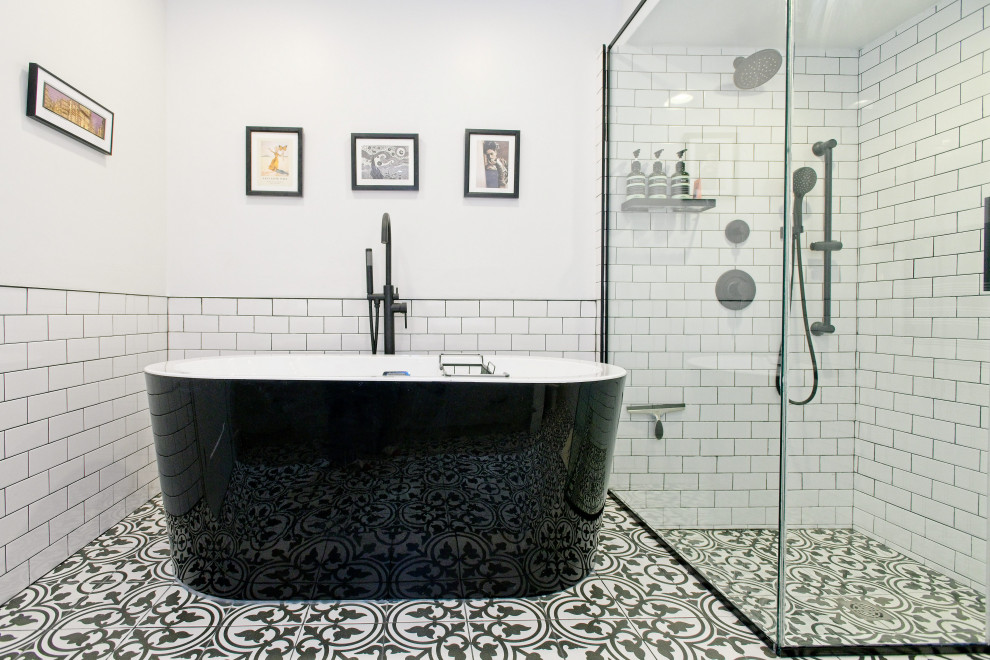This is an example of a medium sized bohemian ensuite bathroom in Toronto with shaker cabinets, grey cabinets, a freestanding bath, a corner shower, a one-piece toilet, white tiles, metro tiles, white walls, porcelain flooring, a submerged sink, quartz worktops, grey floors, a hinged door, white worktops, a single sink and a built in vanity unit.