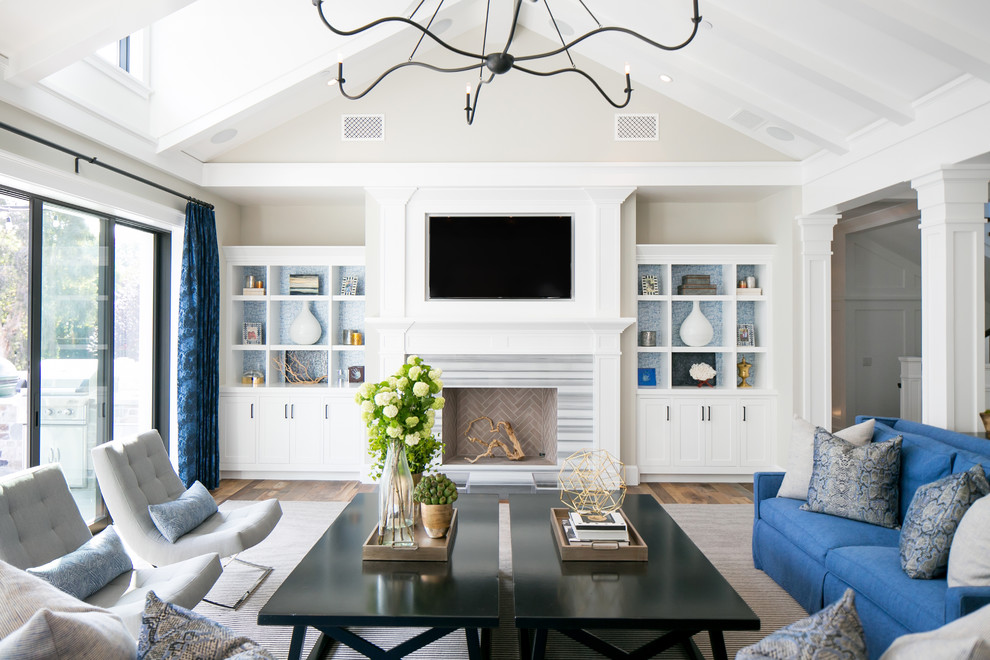 Inspiration for a beach style living room in Orange County with beige walls, a standard fireplace and a wall-mounted tv.