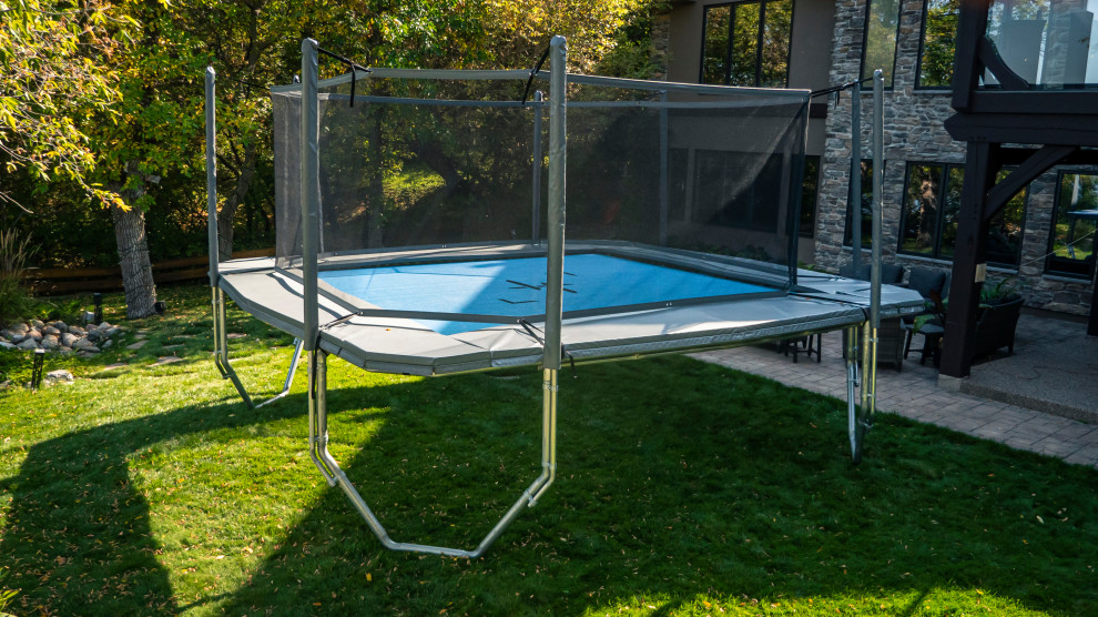 Photo of a large modern partial sun backyard outdoor basketball/tennis/multi-game court for summer.