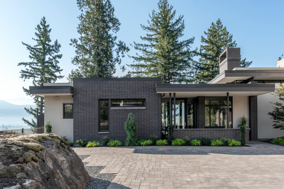 Inspiration for a contemporary two-storey brick house exterior in Vancouver with a flat roof.