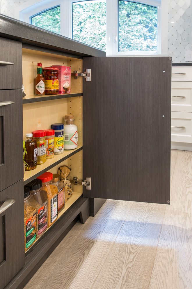 Inspiration for a large transitional l-shaped medium tone wood floor and beige floor eat-in kitchen remodel in Vancouver with an undermount sink, shaker cabinets, white cabinets, granite countertops, gray backsplash, marble backsplash, stainless steel appliances, an island and black countertops