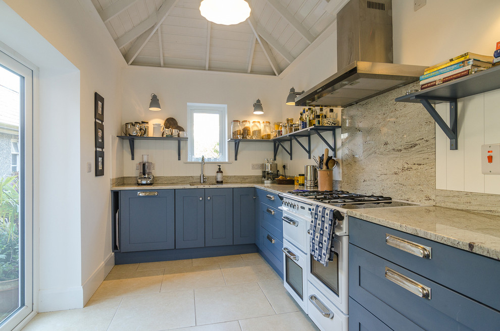 Transitional l-shaped kitchen in Belfast with an undermount sink, shaker cabinets, blue cabinets, beige splashback, white appliances and no island.