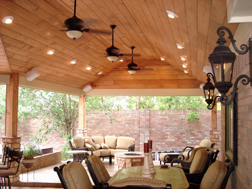 Contemporary backyard patio in Houston with a roof extension, a fire feature and stamped concrete.