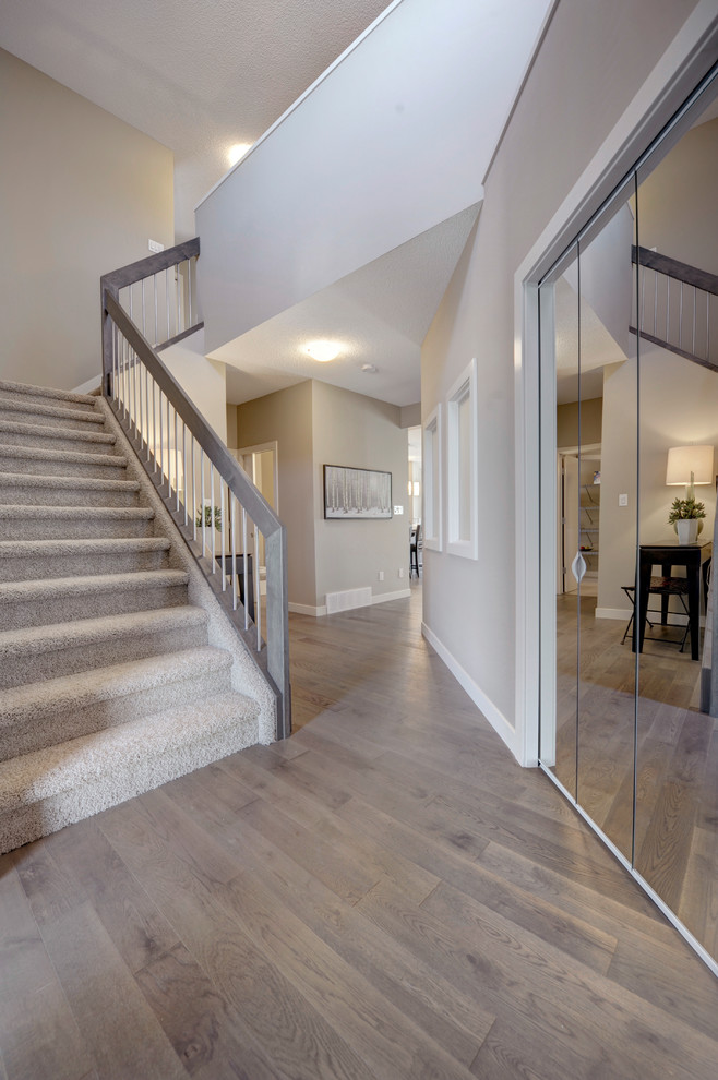 Inspiration for a mid-sized transitional light wood floor and brown floor foyer remodel in Edmonton with gray walls and a gray front door