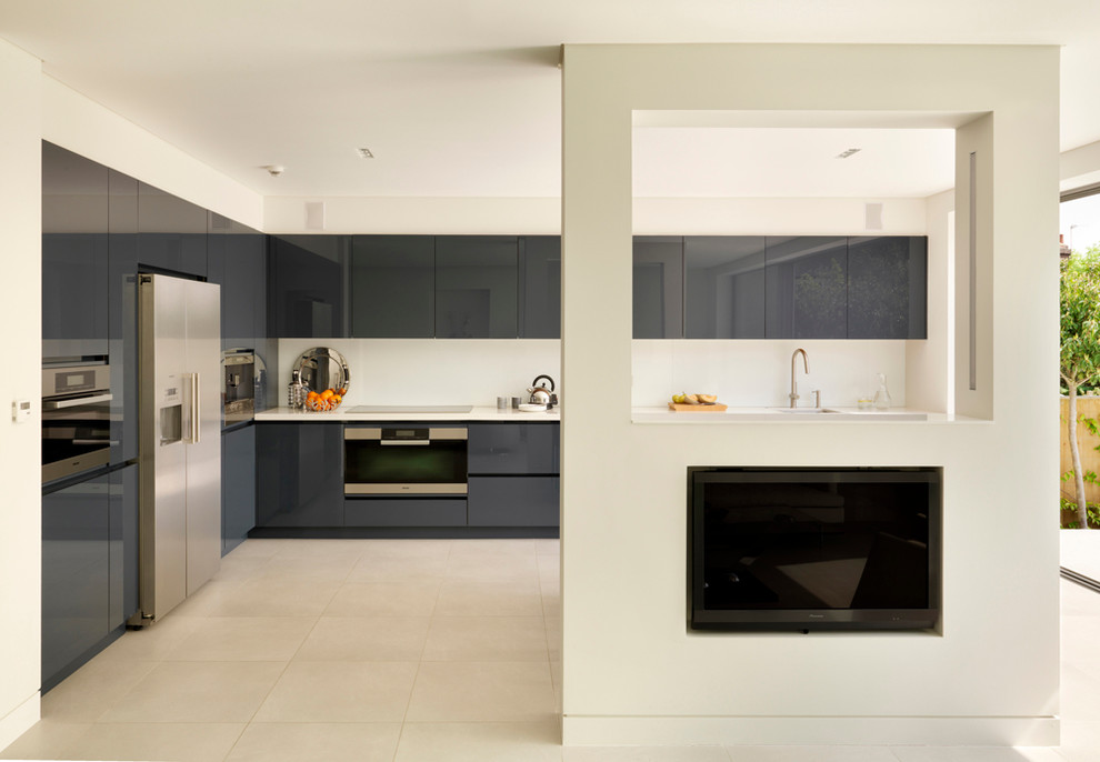 Inspiration for a large contemporary open plan kitchen in London with an undermount sink, flat-panel cabinets, white cabinets, solid surface benchtops and with island.