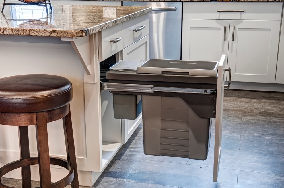 Inspiration for a mid-sized transitional l-shaped vinyl floor eat-in kitchen remodel in Calgary with an undermount sink, shaker cabinets, white cabinets, granite countertops, gray backsplash, subway tile backsplash, stainless steel appliances and an island