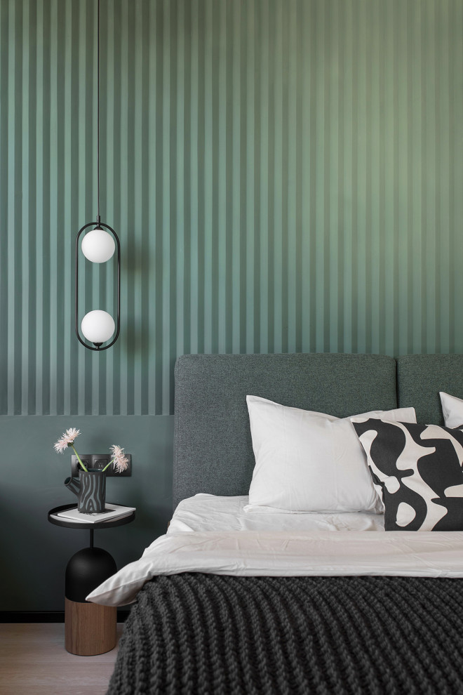Imagen de dormitorio actual pequeño con paredes verdes y suelo laminado