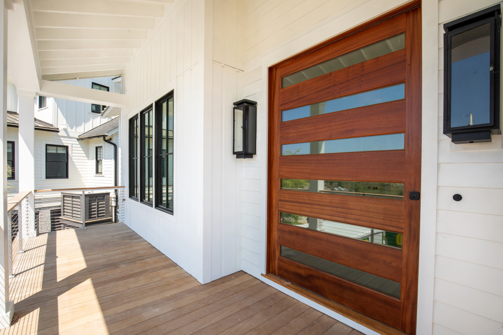 Idées déco pour une grande porte d'entrée moderne avec un mur blanc, une porte pivot, une porte en bois brun et du lambris.