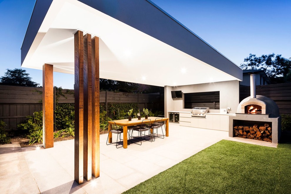 Photo of a mid-sized contemporary backyard patio in Melbourne with an outdoor kitchen, natural stone pavers and a pergola.