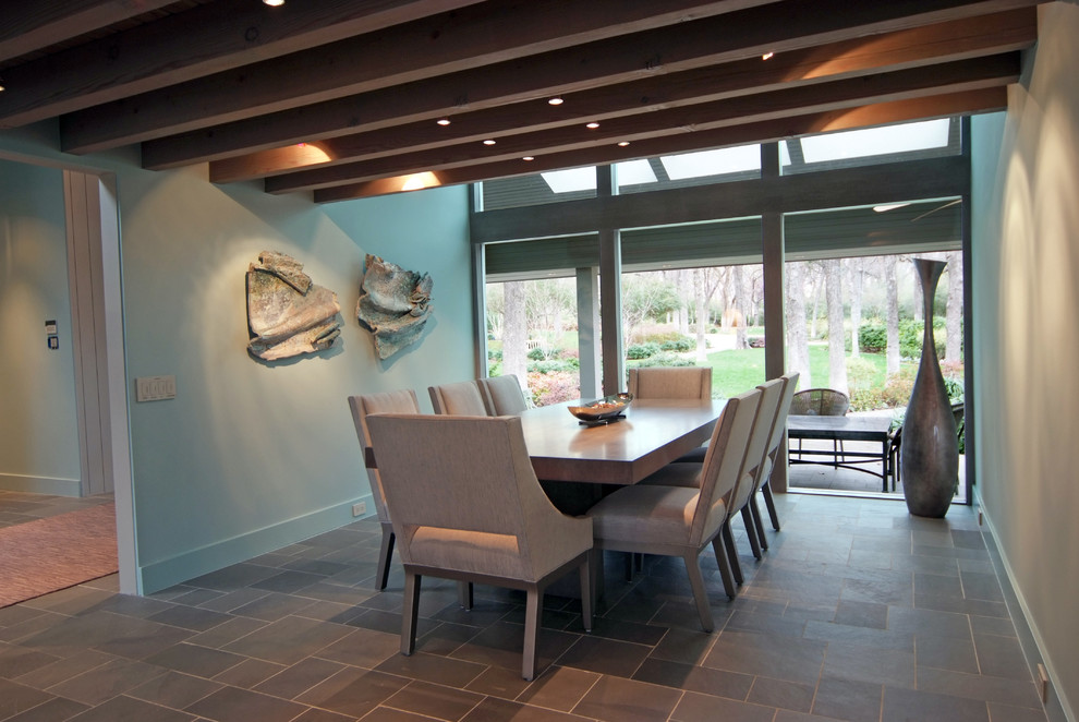 This is an example of a contemporary dining room in Dallas with slate floors.