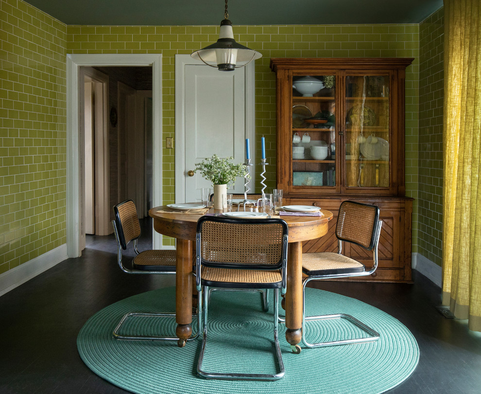 This is an example of a mid-sized eclectic separate dining room in Nashville with green walls, painted wood floors, no fireplace and black floor.