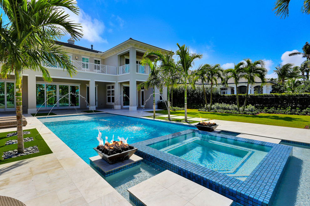 This is an example of a contemporary backyard rectangular pool in Miami with a hot tub.