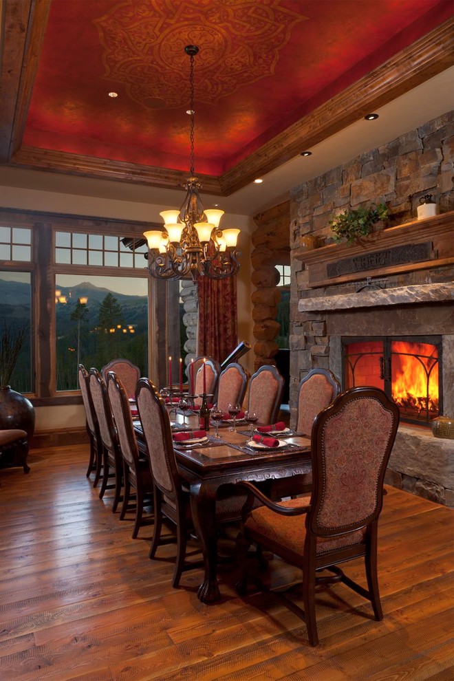 Design ideas for a large country dining room in Other with a standard fireplace and a stone fireplace surround.